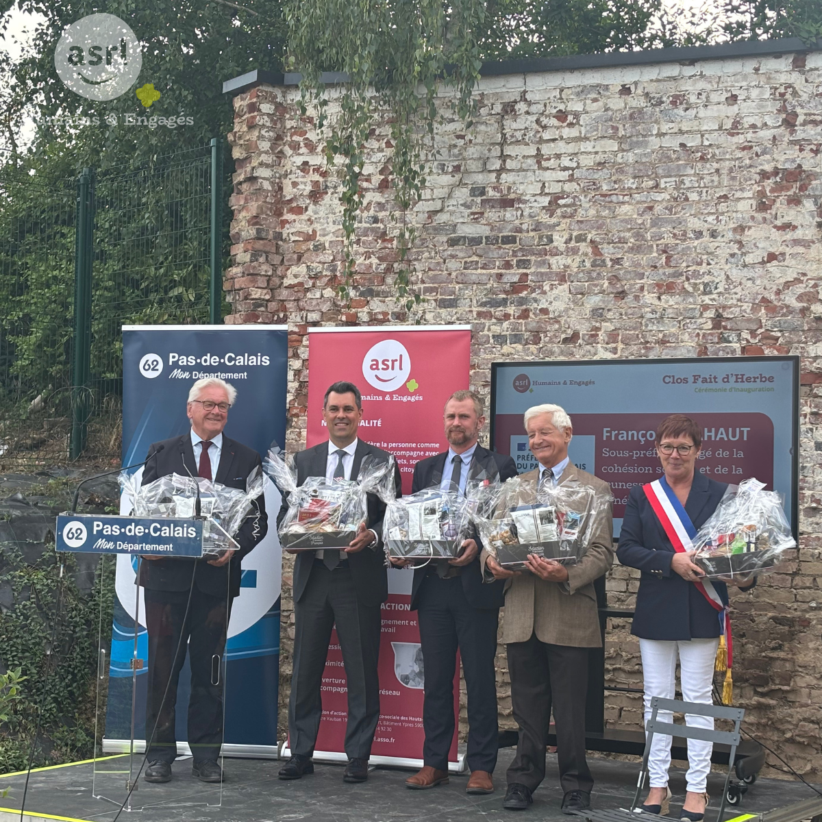 Les représentants officiels et le directeur de l'ASRL tenant les cadeaux remis par les résidents